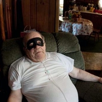 Man in recliner using an oxygen tank